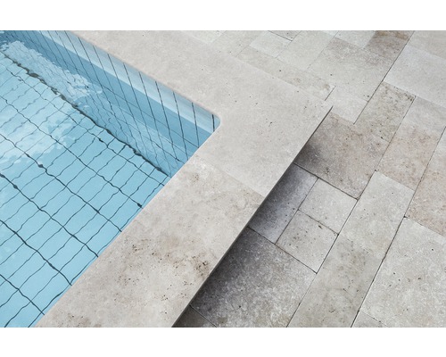 Detailansicht eines Schwimmbeckens mit Travertin-Umrandung und Travertin-Terrassenplatten