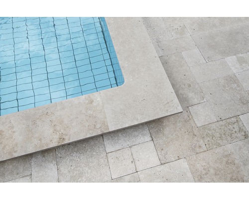 Detailansicht eines Pools mit Travertin-Umrandung und -Fliesen