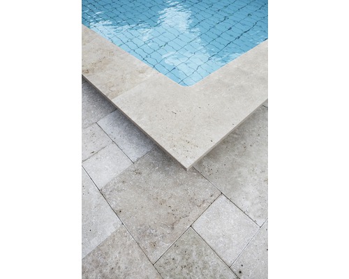 Detailansicht eines Pools mit Travertin Poolumrandung und Bodenplatten.