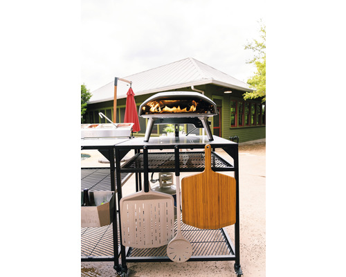 Pizzaofen mit Zubehör auf einem rollbaren Tisch im Freien