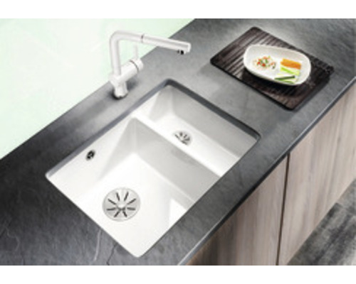 Küchenspüle mit Abtropffläche und Armatur auf dunkler Arbeitsplatte.