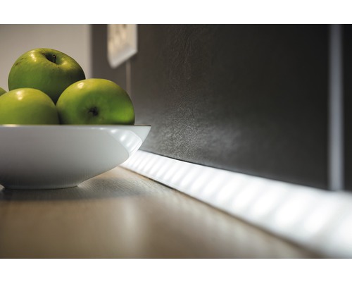 Dekorative Küchenszene mit LED-Lichtleiste und einer Schale mit Äpfeln