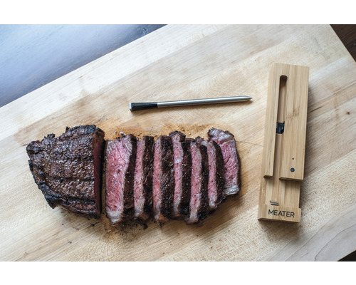 Angeschnittenes Steak mit Fleischthermometer auf Holzbrett