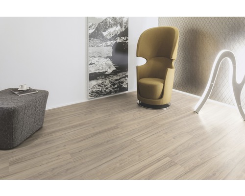 Wohnraum mit hellem Laminatboden, Sessel, Hocker und Dekoration