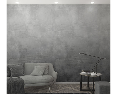 Graue Wandgestaltung mit Sofa, Tisch und Lampe in einem Wohnraum.