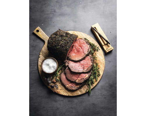 Rinderbraten auf Holzbrett mit Salz und Thermometer