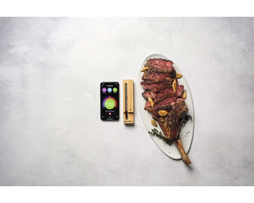 Intelligentes Fleischthermometer mit App und Tomahawk Steak auf einem Teller