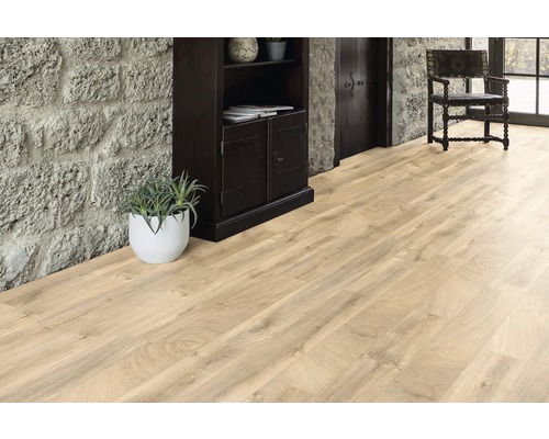 Heller Holzboden in einem Raum mit Steinwand, dunklem Holzschrank und Stuhl