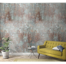 Wohnzimmer mit gelbem Sofa, Zimmerpflanze und Wandtapete im Rostdesign