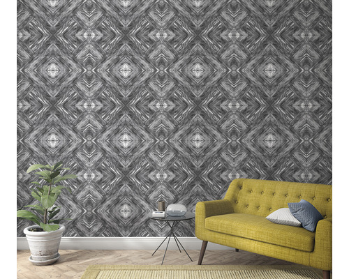 Wohnzimmer mit gemusterter Tapete, Sofa und Zimmerpflanze