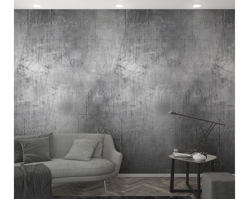 Wohnzimmer mit einer grauen Couch und einer Wand mit Nieten-Optik