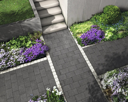 Gartenweg mit Pflastersteinen und Blumenbeeten