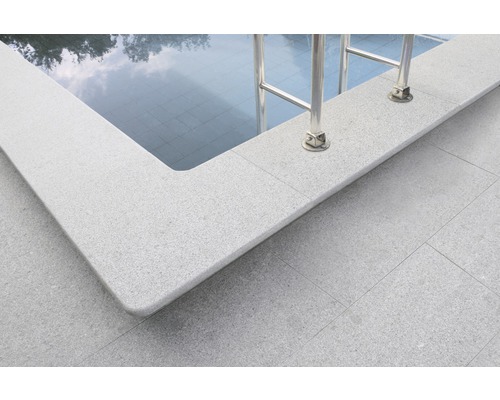 Detailansicht eines Pools mit Beckenrandsteinen und einer Leiter.