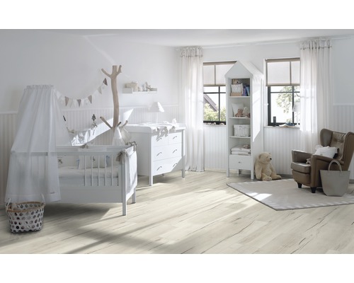 Helles Kinderzimmer mit Kinderbett, Wickeltisch, Bücherregal und Sessel auf hellem Holzboden