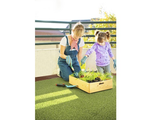 Mutter und Tochter gärtnern gemeinsam in einem Hochbeet auf einem Balkon
