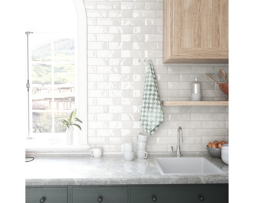 Küchenszene mit Spüle, Fliesenwand und Fenster