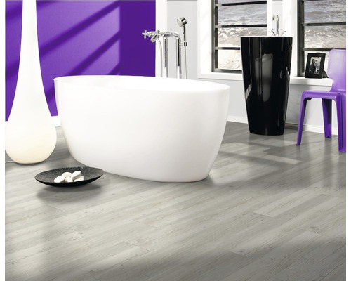 Badezimmer mit freistehender Badewanne, schwarzem Waschtisch, lila Stuhl und hellem Holzboden