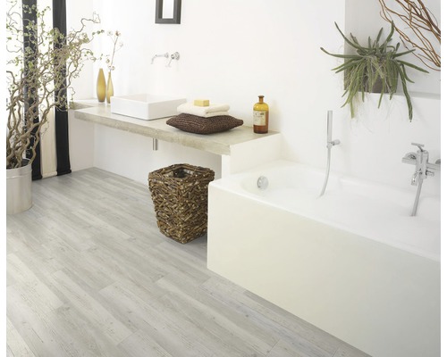 Badezimmer mit Badewanne, Waschbecken, Holzboden und Pflanzen
