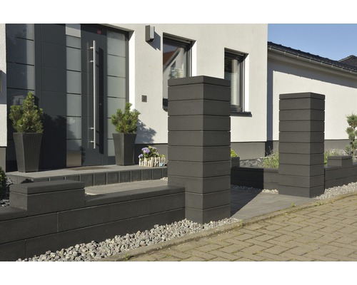 Eingangsbereich eines Hauses mit Pflastersteinen, Mauersystem und Pflanzen