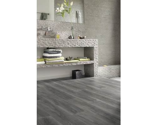 Helles Badezimmer mit Waschtisch und grauem Laminatboden.