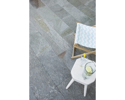 Außenbereich mit Natursteinplatten, Liegestuhl und Beistelltisch mit Getränken