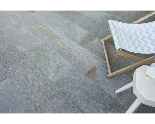 Verlegter Natursteinboden mit Liegestuhl und Beistelltisch