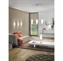 Wohnzimmer mit Sofa, Teppich, Couchtisch und verschiedenen Lampen zur Raumbeleuchtung.