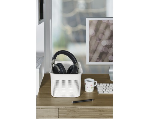 Schreibtischszene mit Aufbewahrungskorb, Kopfhörern, Tasse und Stift