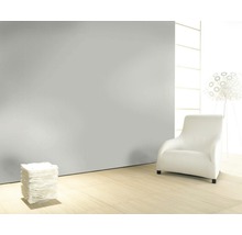 Helles Wohnzimmer mit Sessel, Stehlampe und Dekorationselementen