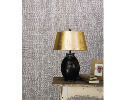 Szene mit Textiltapete, Lampe und Dekoration auf einem Tisch