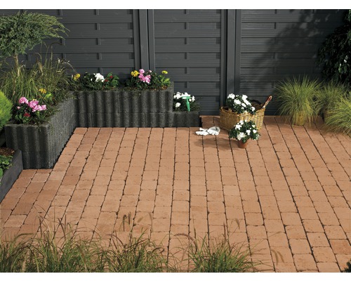 Terrasse mit Pflastersteinen, Pflanzkästen und Holzzaun