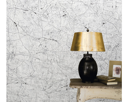 Tapete mit Rissmuster neben Tischlampe und Bilderrahmen