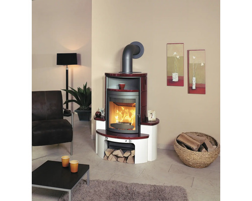 Wohnzimmer mit Kaminofen, Sessel und Holzkorb