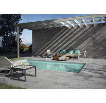 Außenbereich mit Pool, Terrassenfliesen, Wandfliesen und Gartenmöbeln.