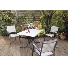 Gartenszene mit einem Tisch und drei Stühlen auf einer Terrasse