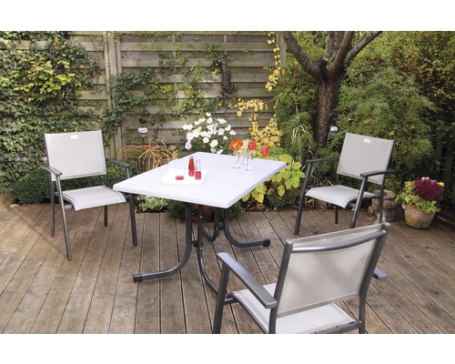 Gartenszene mit einem Tisch und drei Stühlen auf einer Terrasse