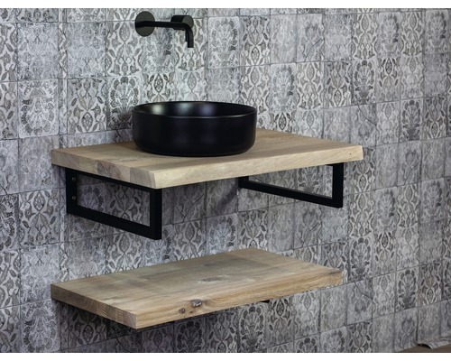 Badezimmer mit Waschtisch, schwarzem Aufsatzwaschbecken, zwei Holzablagen und Armatur vor gemusterter Wand