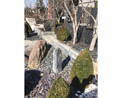 Dekorative Gartengestaltung mit Ziersteinen, Findlingen, Büschen und Bäumen für eine naturnahe Gartengestaltung.