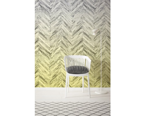 Dekoratives Interieur mit einem weißen Stuhl und einer Stehlampe vor einer Wand mit Fischgrätenmuster