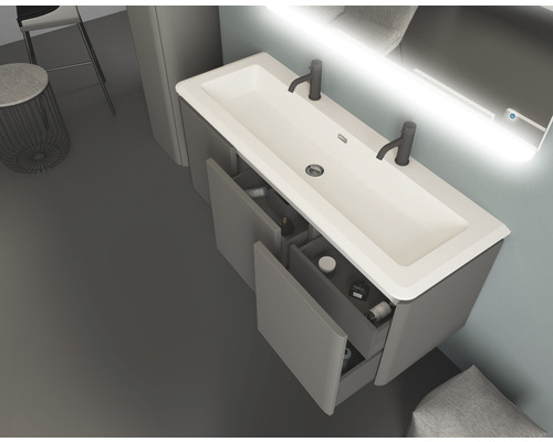 Modernes Badezimmer mit Waschbecken, Unterschrank mit offenen Schubladen und beleuchtetem Spiegel