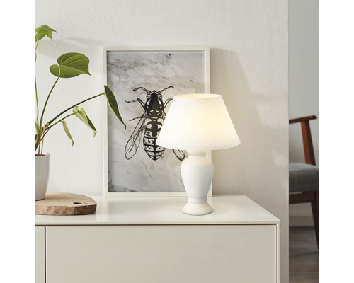 Tischleuchte auf Kommode mit Dekoration und Bild