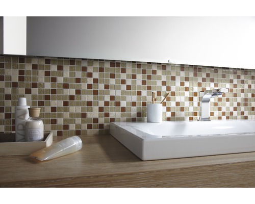 Badezimmer mit Mosaikfliesen, Waschbecken und Armaturen.