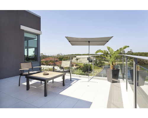 Terrasse mit Sitzgruppe, Sonnenschirm und Pflanzenkübeln