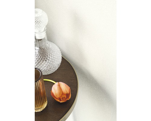 Dekorative Tapete an einer Wand neben einem Tisch mit Karaffe und Blume.