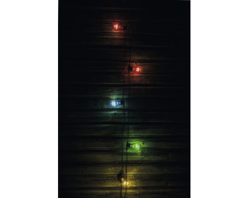 Dekorative Lichterkette mit verschiedenfarbigen Glühbirnen vor Holzwand