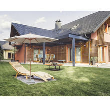 Garten mit Liegestuhl, Sonnenschirm, Sitzgruppe und Feuerstelle vor einem Wohnhaus.