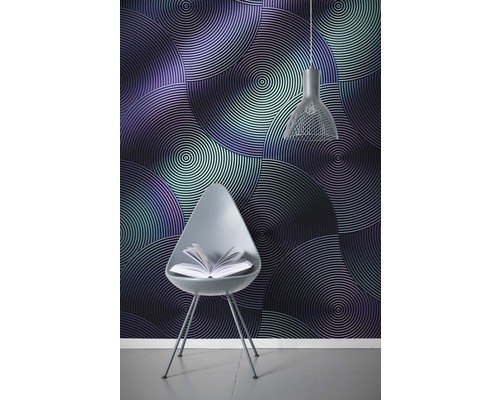Raumansicht mit einer Wandtapete mit konzentrischen Kreisen, einem Stuhl mit einem Buch und einer Hängelampe