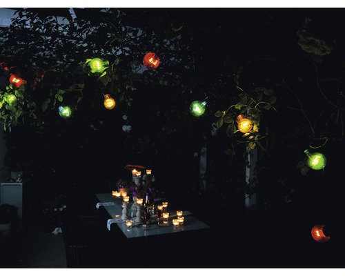 Beleuchteter Gartentisch mit dekorativer Lichterkette im Außenbereich.