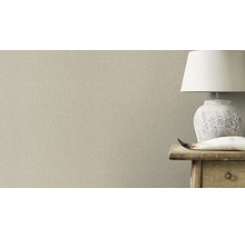 Nahaufnahme einer dezent gemusterten Tapete neben einem Nachttisch mit Lampe