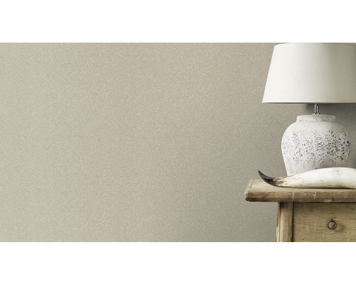 Nahaufnahme einer dezent gemusterten Tapete neben einem Nachttisch mit Lampe